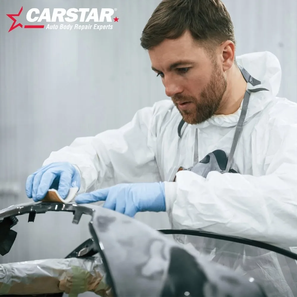 A technician inspecting a body panel before repair